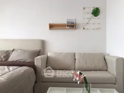 Modern living room with beige sofa and cozy bed in stylish apartment