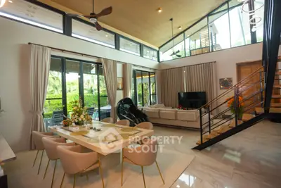 Luxurious open-plan living and dining area with high ceilings and modern decor.
