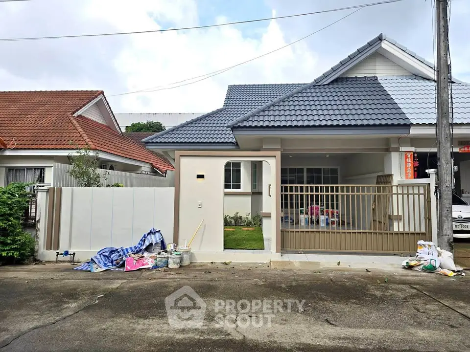 Charming suburban house with modern roof and gated driveway, perfect for family living.