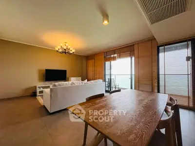 Spacious living room with modern decor and balcony view, perfect for relaxation.