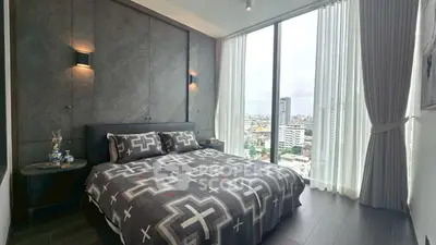 Modern bedroom with large windows offering city views and stylish decor.