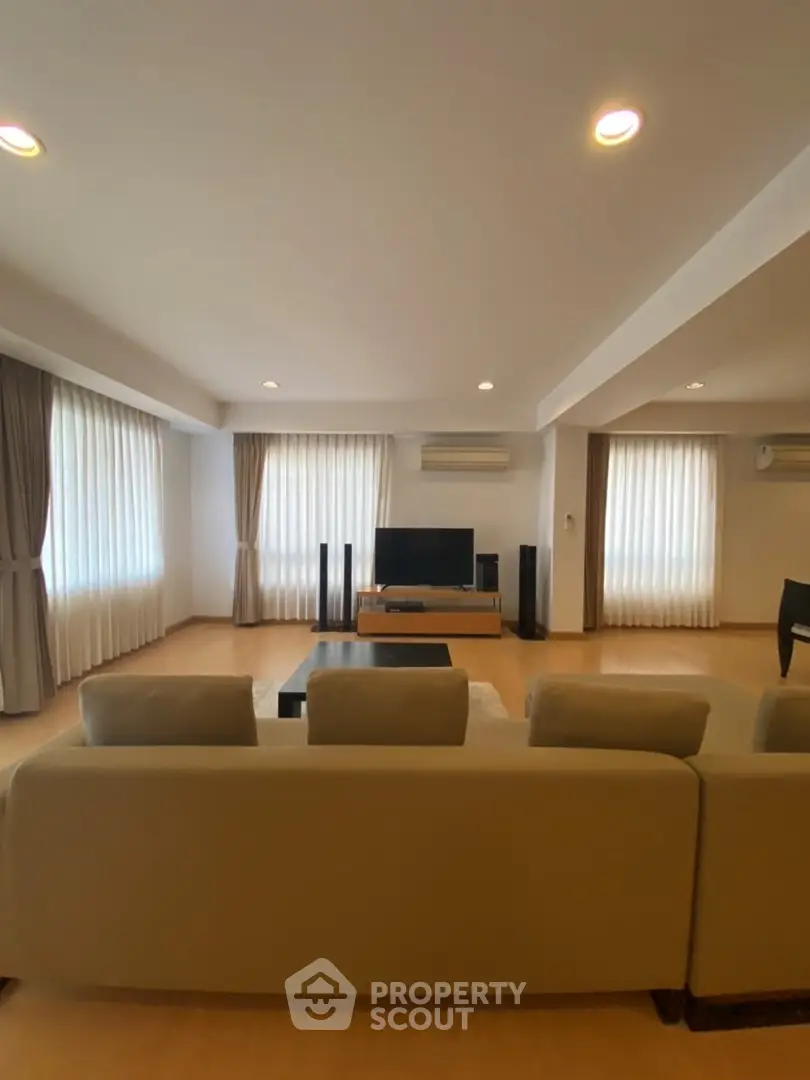 Spacious living room with modern decor and ample natural light
