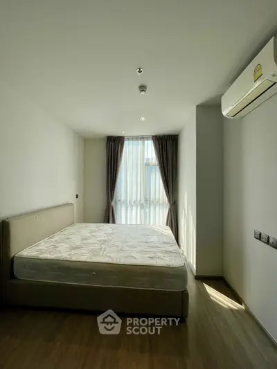 Spacious bedroom with natural light and modern air conditioning unit