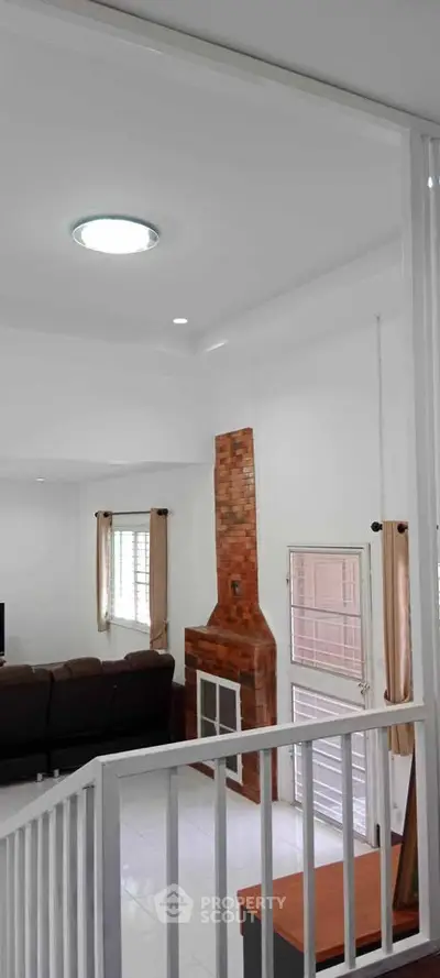 Spacious living room with modern decor and brick fireplace