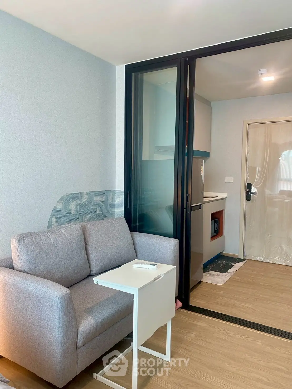 Modern living room with sliding glass door to compact kitchen in stylish apartment