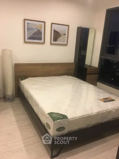Modern bedroom with stylish decor and large window offering city views, featuring a comfortable bed and sleek furniture.