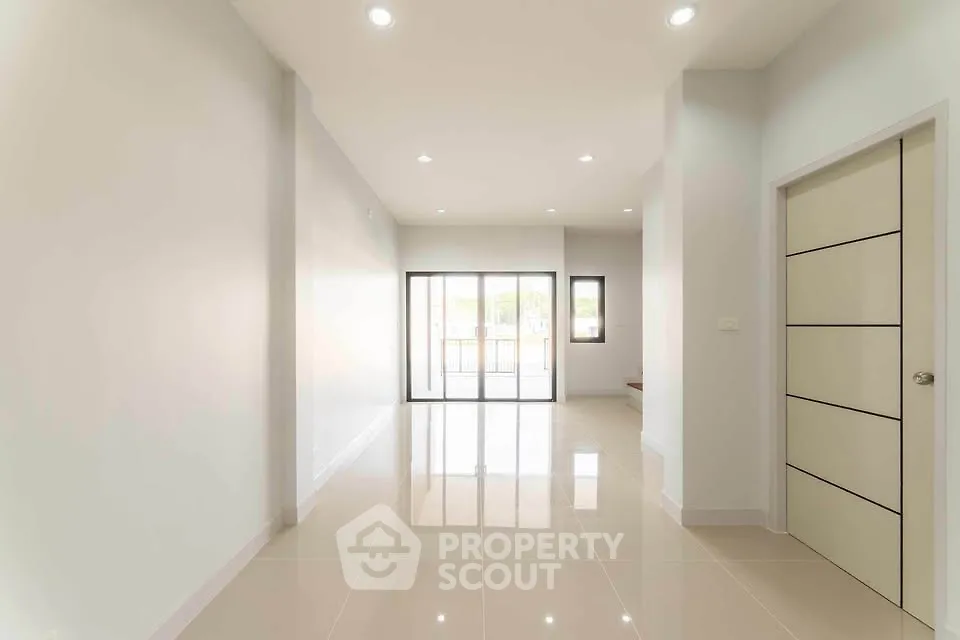 Spacious modern living room with glossy tiled floors and large windows.