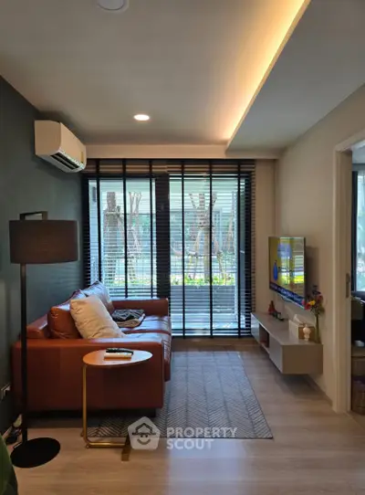 Modern living room with leather sofa and large windows offering natural light