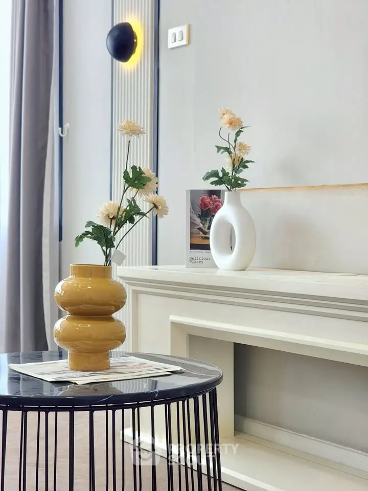 Stylish modern living room with elegant decor and unique vases on a chic table.