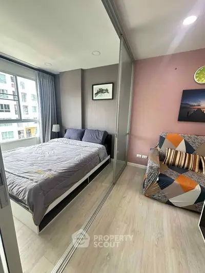 Modern bedroom with large window and stylish decor in a high-rise apartment.