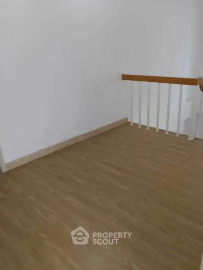 Spacious corner unit with elegant wooden flooring and modern railing design.