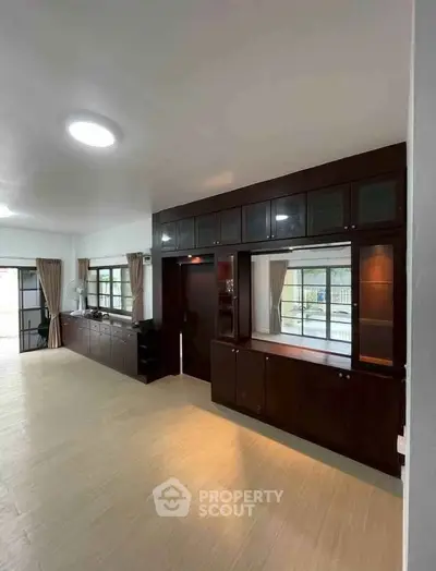 Spacious living room with elegant built-in cabinets and large windows for natural light.