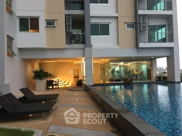 Modern apartment building with pool and gym facilities, perfect for luxury living.