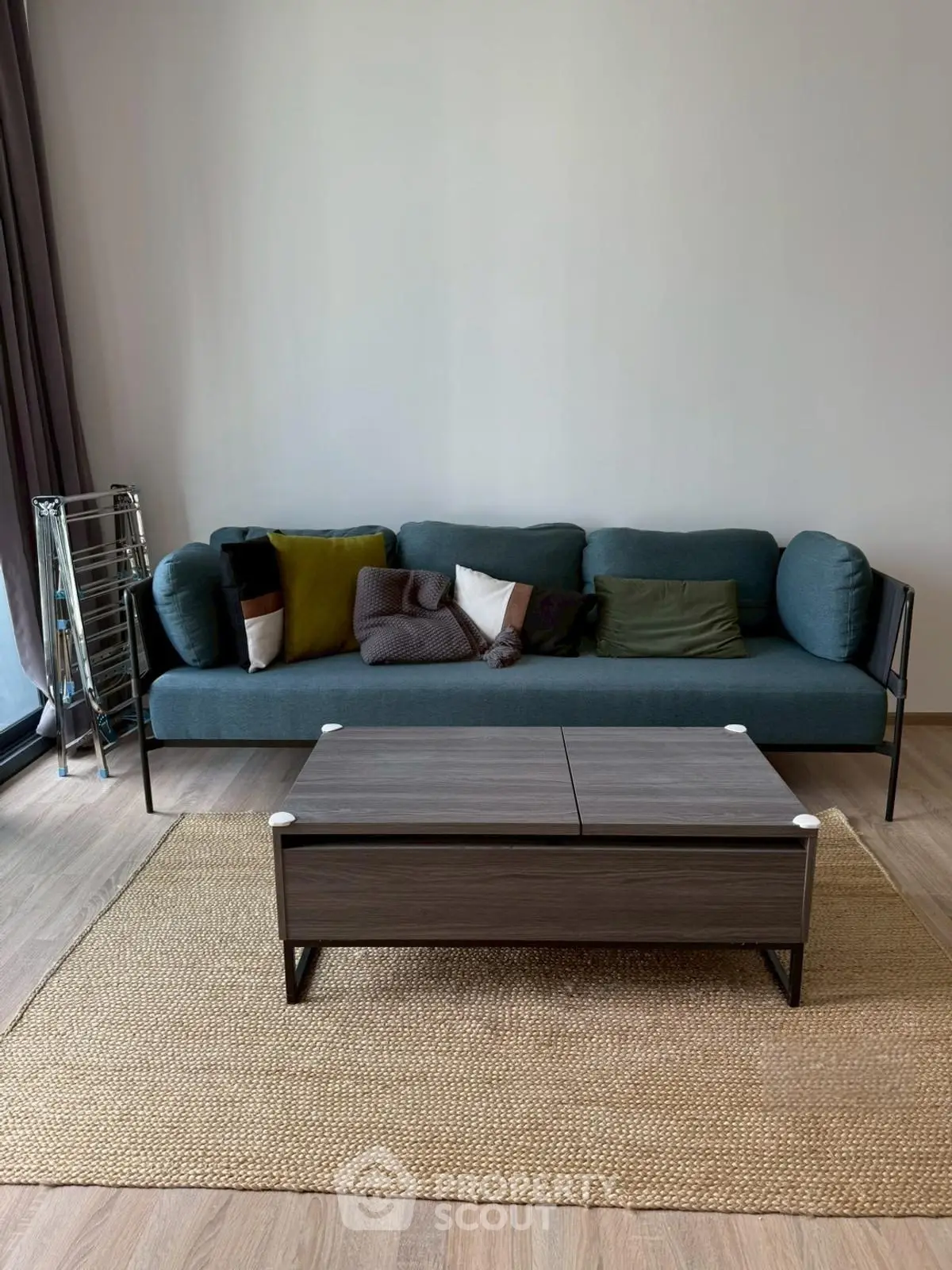 Modern living room with stylish blue sofa and sleek coffee table on wooden floor.