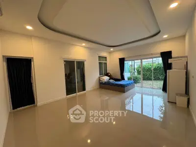 Spacious bedroom with large windows and garden view in modern home