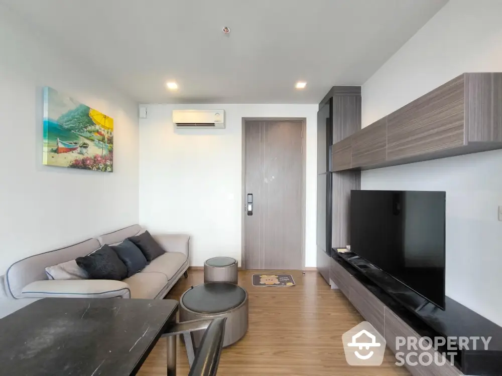 Modern living room with sleek furniture and wall-mounted TV in a stylish apartment.