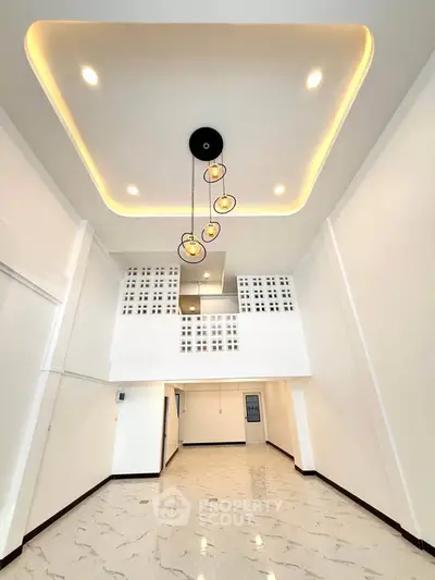 Spacious modern living room with high ceiling and elegant lighting