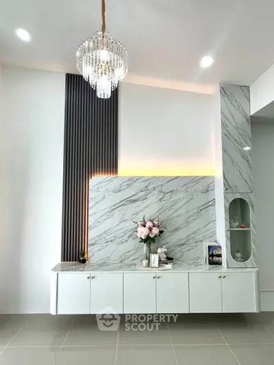 Elegant living room with modern marble accent wall and chandelier