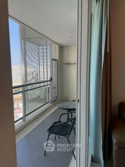 Spacious balcony with modern seating and city view, perfect for relaxation.