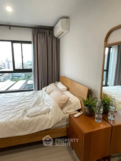 Cozy bedroom with city view, featuring a wooden bed and modern decor, perfect for urban living.