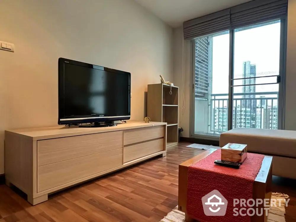 Modern living room with balcony view, featuring sleek furniture and natural light.