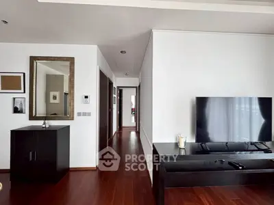 Modern living room with sleek wooden flooring and large TV setup