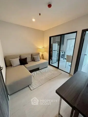 Modern living room with cozy sofa and open kitchen view in stylish apartment.