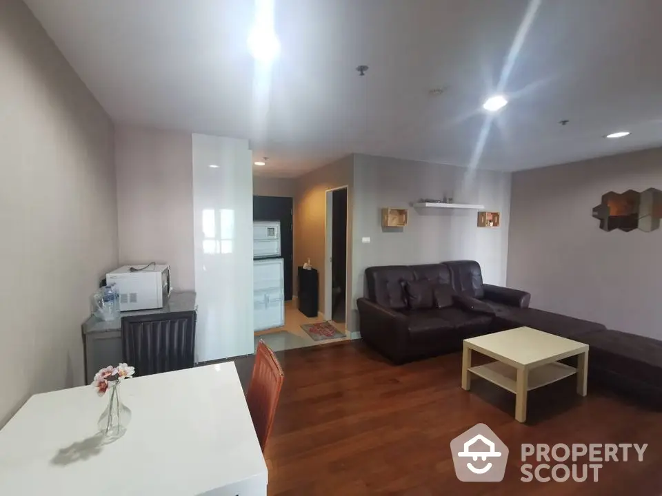 Spacious living room with modern furniture and wooden flooring in a stylish apartment.