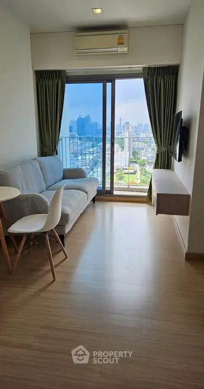 Modern living room with city view, featuring sleek furniture and large windows for natural light.