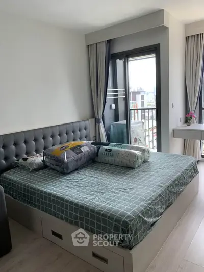 Modern bedroom with stylish decor and balcony access in urban apartment