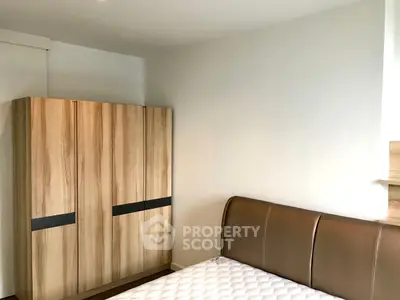 Modern bedroom with sleek wooden wardrobe and stylish bed frame, perfect for a cozy retreat.