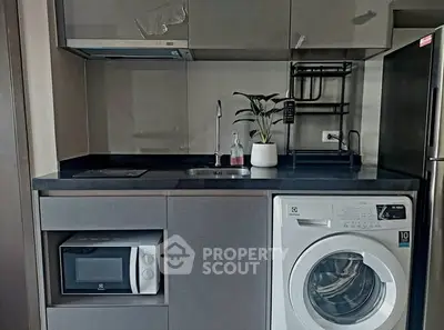 Modern compact kitchen with washing machine and microwave in sleek design.