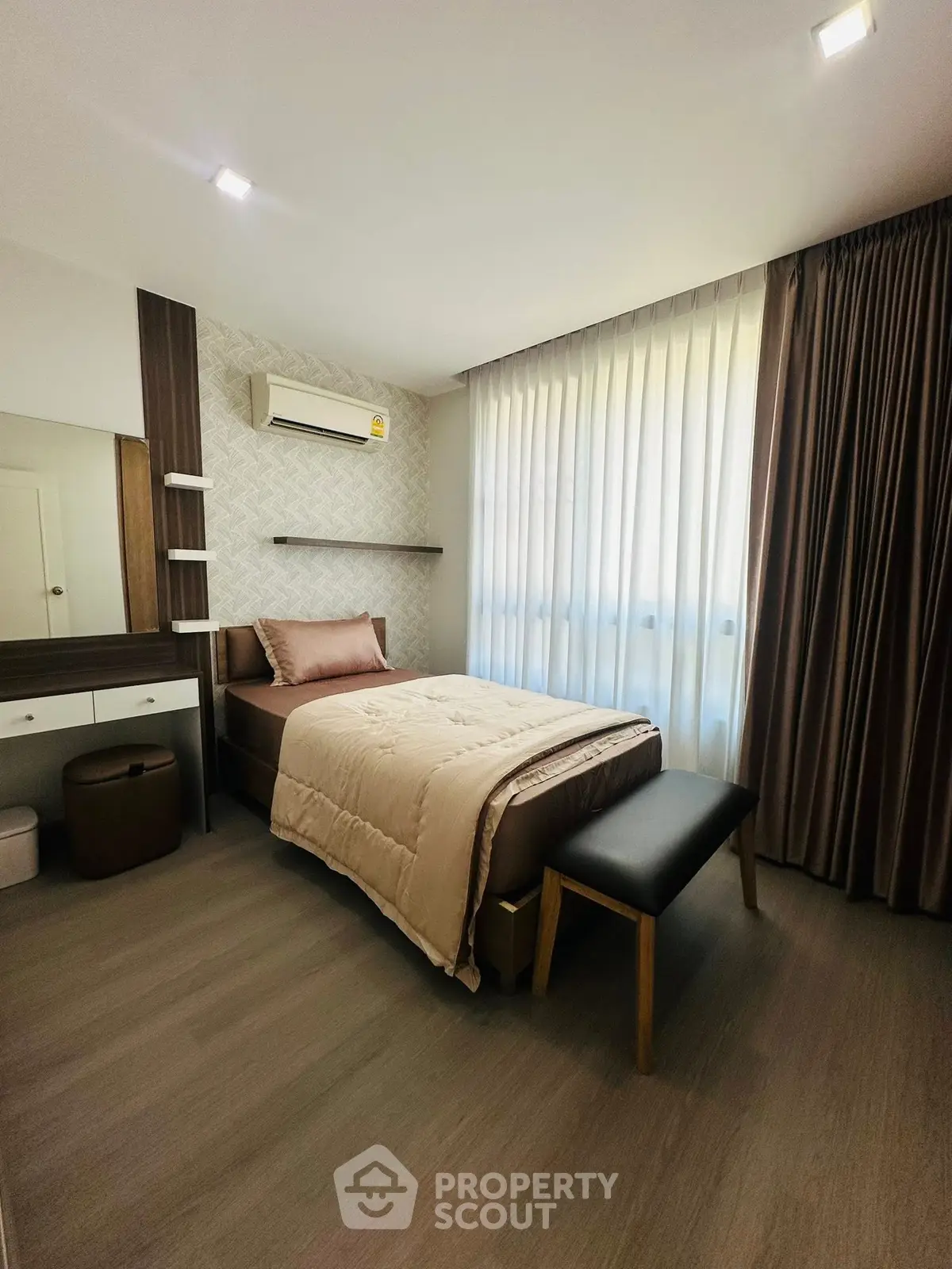 Cozy bedroom with modern decor and natural light, featuring a single bed and stylish furnishings.