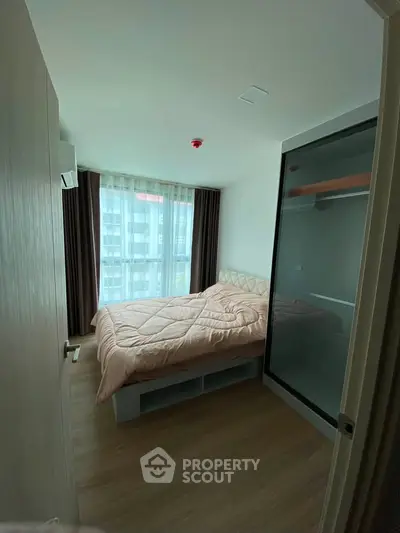 Cozy bedroom with large window and modern furnishings in a stylish apartment.