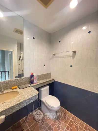 Modern bathroom with tiled walls and granite countertop