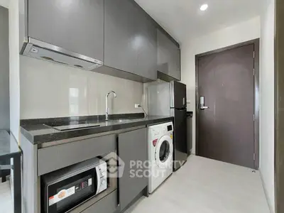 Modern kitchen with sleek cabinets, built-in appliances, and compact layout in a stylish apartment.