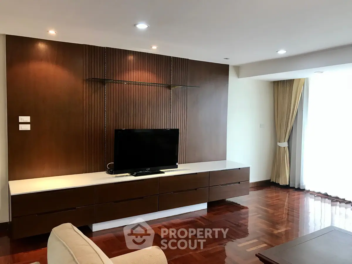 Spacious living room with modern wooden TV cabinet and elegant lighting