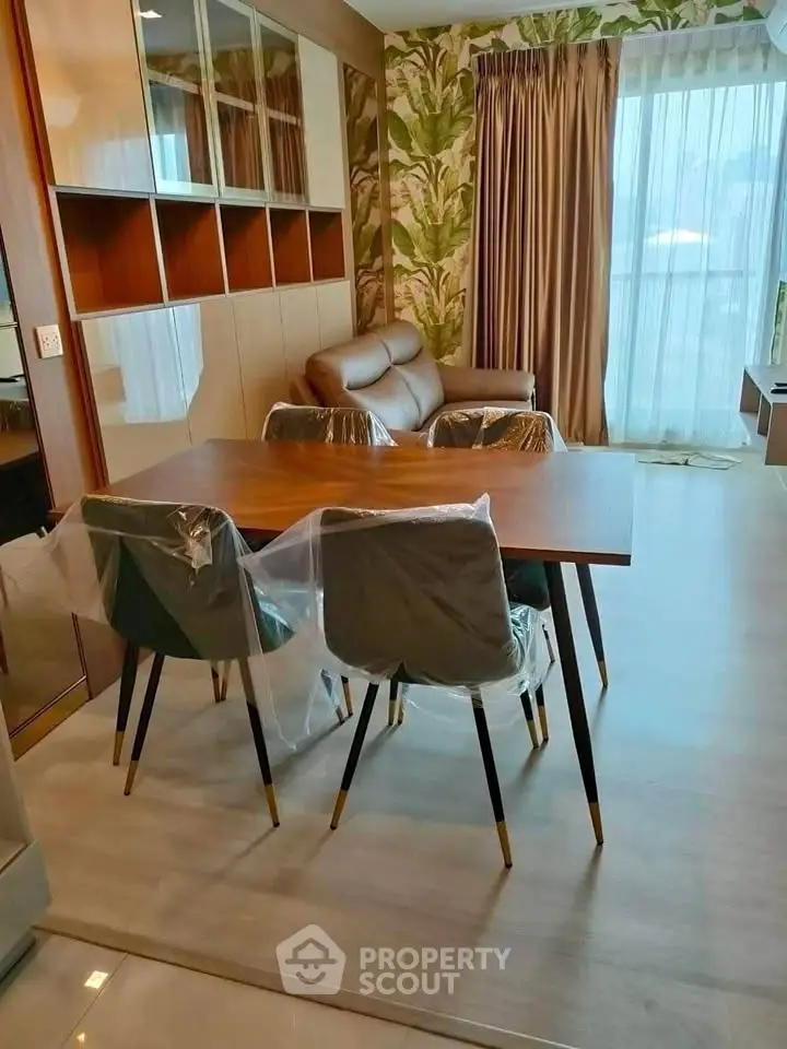 Modern living room with stylish dining set and cozy sofa, featuring elegant decor and large window with natural light.