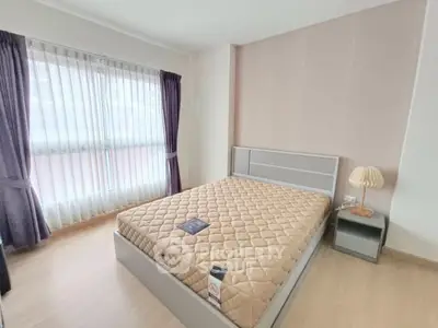 Spacious bedroom with large window and modern decor in a stylish apartment.