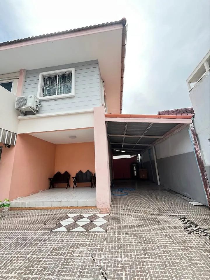 Charming two-story house with covered parking and tiled patio, perfect for family living.