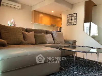 Modern living room with stylish sofa and open kitchen layout