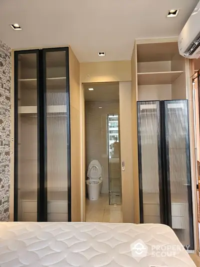 Modern bedroom with ensuite bathroom and sleek storage solutions