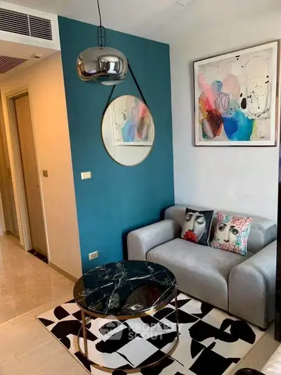 Stylish living room with modern decor, featuring a chic sofa, abstract art, and a sleek coffee table.