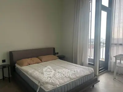 Spacious bedroom with large windows and balcony access, offering a serene view and modern furnishings.