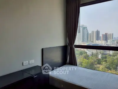 Modern bedroom with large window offering stunning city view