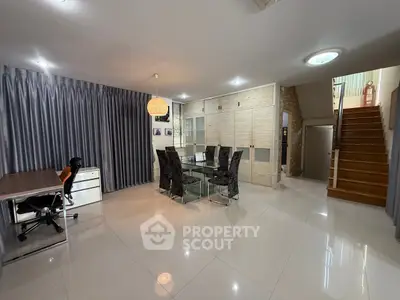 Spacious modern living room with dining area and study desk, featuring elegant decor and ample natural light.