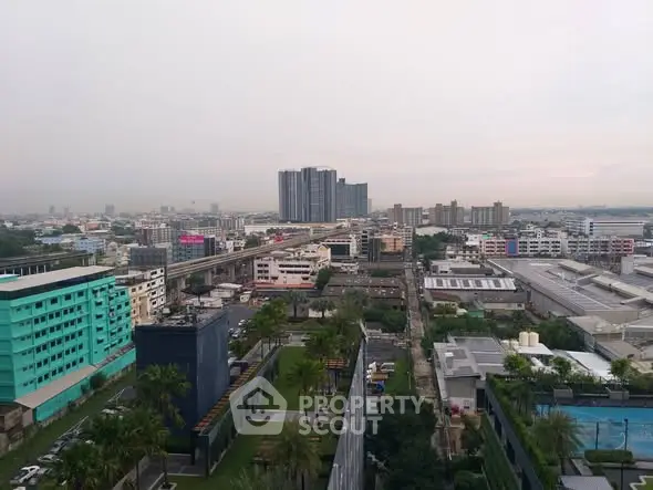 Stunning cityscape view from a high-rise building showcasing urban skyline and lush greenery.