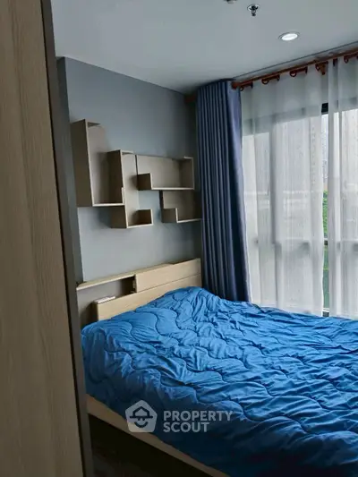 Cozy bedroom with modern decor and large window for natural light.