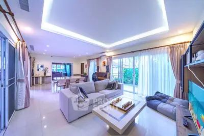 Spacious modern living room with elegant decor and large windows offering garden views.