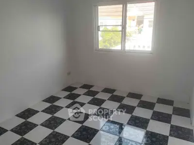 Bright empty room with checkered tile flooring and large window